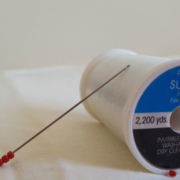 Spiral Eye Beading needle with three seed beads and invisible thread